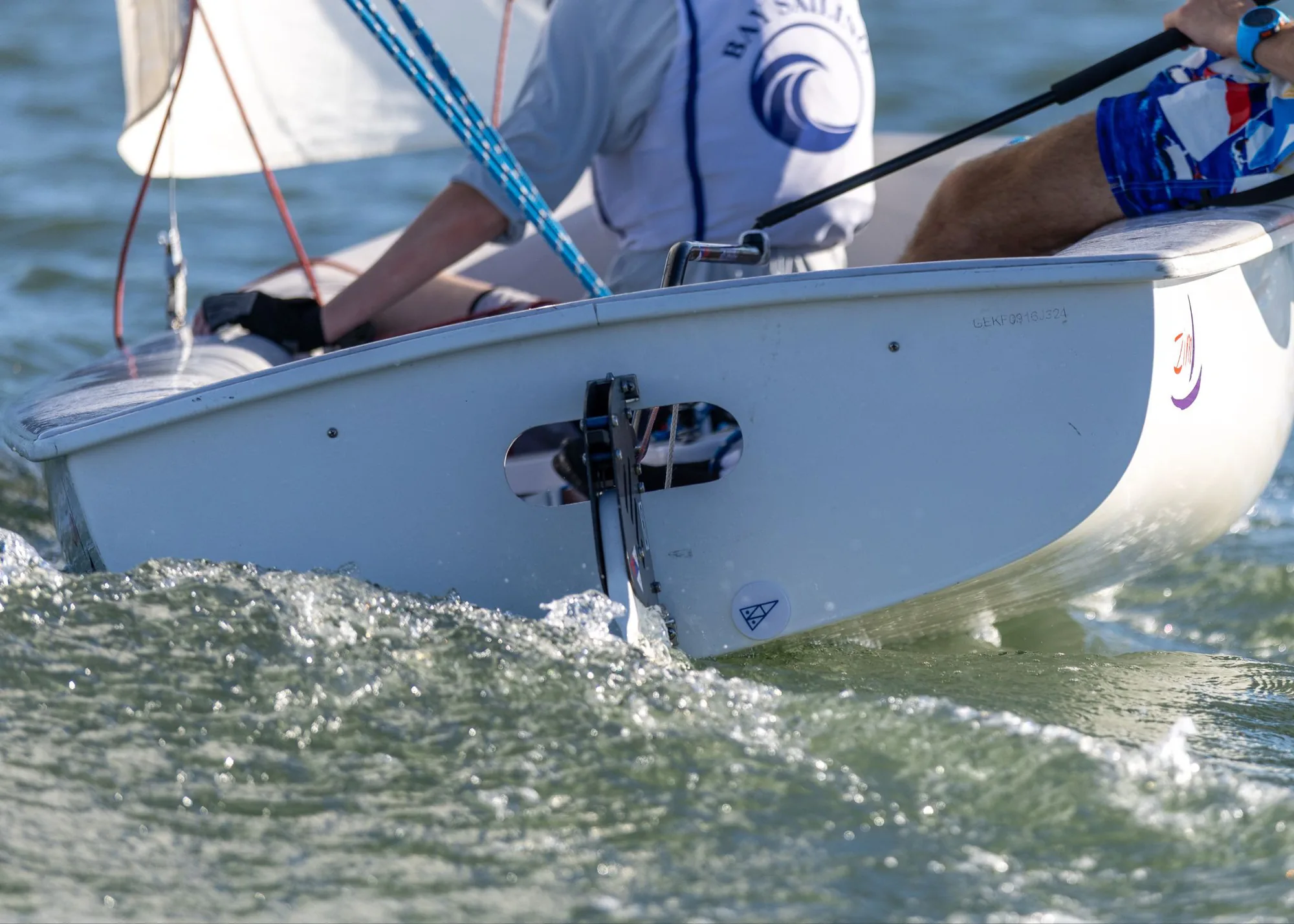 The stern of an FJ dinghy sailing upwind, with a ProPlug fitted in the transom drain.
